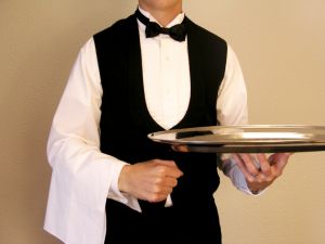 waiter at a table with restaurant table tents from MenuCoverMan.com